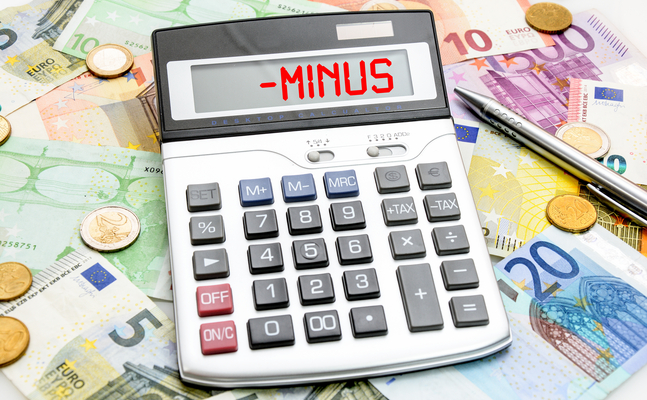 Bild zeigt einen Taschenrechner mit der Aufschrift Minus und dahinter liegen Euroscheine 