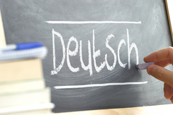 Bild zeigt eine Schultafel mit der Aufschrift Deutsch imit Kreide geschrieben